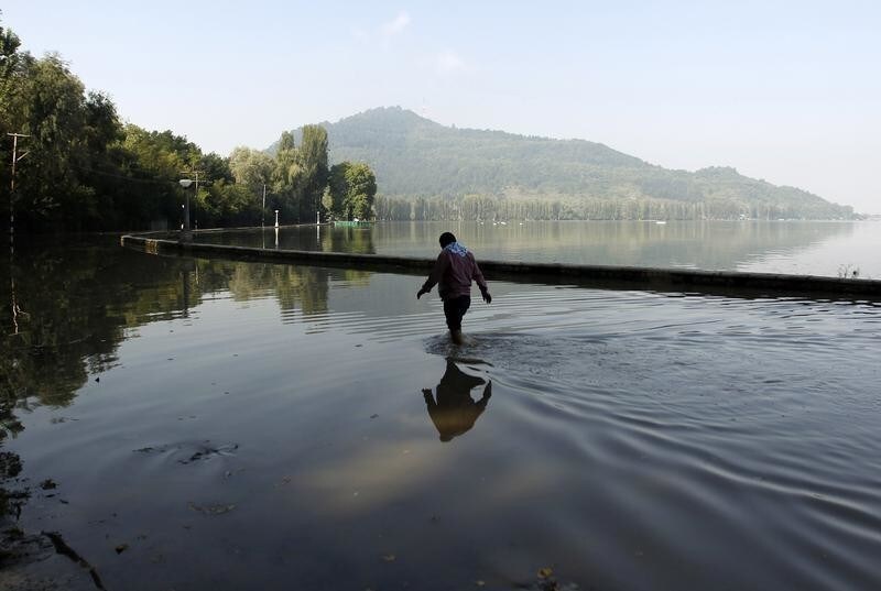 A man wades through a flooded road along the banks of Dal Lake in Srinagar September 18, 2014. Both the Indian and Pakistani sides of the disputed Himalayan region have seen extensive flooding this month with Srinagar particularly hard hit. Hundreds of people have been killed and tens of thousands are homeless. REUTERS/Danish Ismail (INDIAN-ADMINISTERED KASHMIR - Tags: DISASTER ENVIRONMENT) - GM1EA9I1A0701