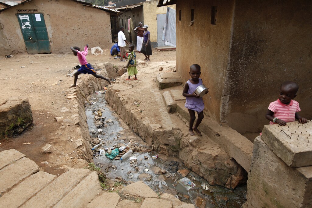 A child leaps across an open sewer in Kisenyi, a slum in Kampala, March 28, 2009. MALTA OUT. NO COMMERCIAL OR EDITORIAL SALES IN MALTA REUTERS/Darrin Zammit Lupi (UGANDA) - RTXESAG