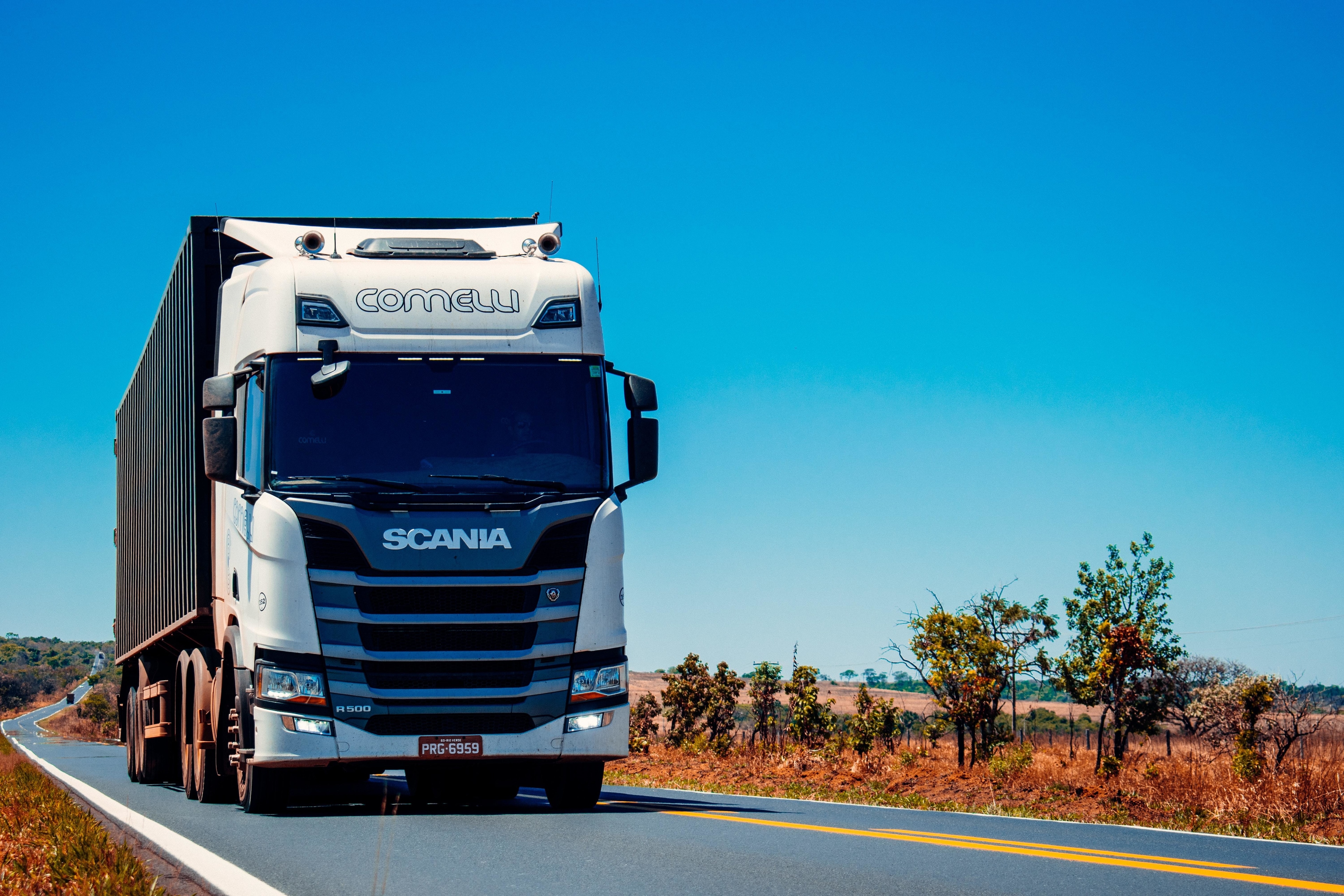 A truck on the road with a blue sky in the background.