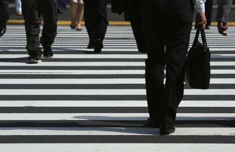 Pedestrians cross a road at Tokyo's business district September 30, 2014. Japanese big manufacturers' confidence improved slightly in the three months to September, a closely watched central bank survey showed, but service-sector sentiment worsened, adding to evidence that a sales tax hike continues to weigh on the economy. Picture taken September 30, 2014. To match JAPAN-ECONOMY/TANKAN REUTERS/Yuya Shino (JAPAN - Tags: BUSINESS EMPLOYMENT) - RTR48F1Y