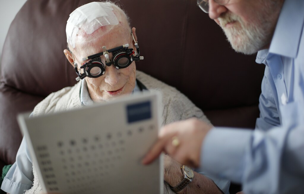 Resident Ernie Mayes, 89, has his eyes checked by Optometrist in his flat at the Colbrooke House care facility run by a private company working on behalf of the local government and housing association in southeast London February 13, 2015. The provision of care for those who can no longer look after themselves but do not require a place in hospital is one of the biggest problems facing the state-funded National Health Service. The involvement of the private sector in critical services remains a contentious issue in Britain after large outsourcers failed in previous high profile contracts. REUTERS/Suzanne Plunkett (BRITAIN - Tags: POLITICS HEALTH SOCIETY) - LM1EB2J0R3W01