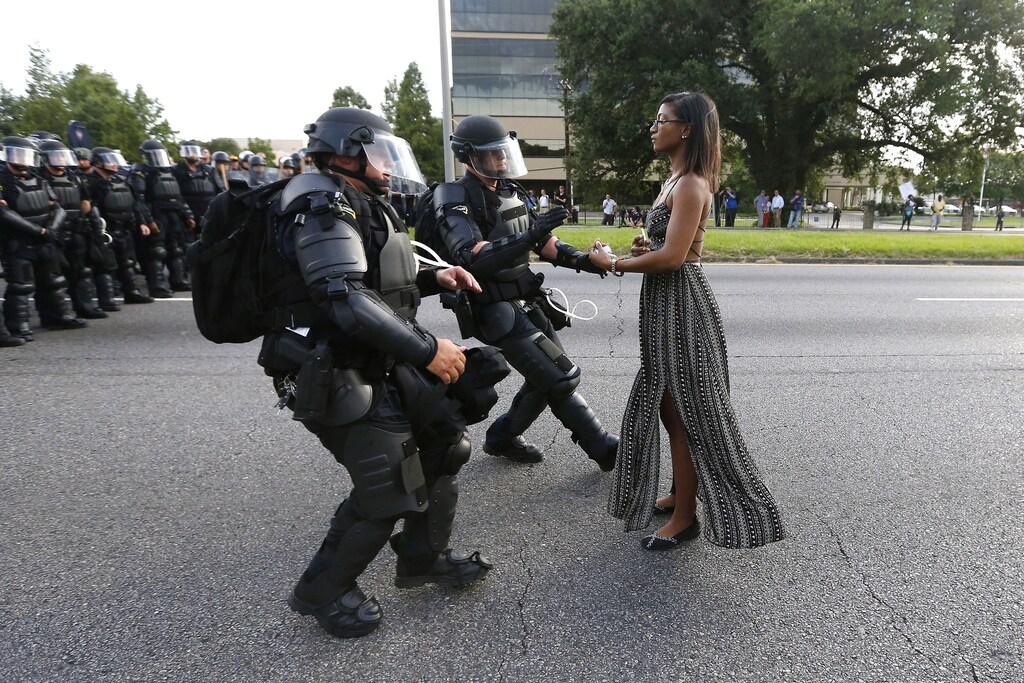 Lone activist Ieshia Evans stands her ground while offering her hands for arrest as she is charged by riot police during a protest against police brutality outside the Baton Rouge Police Department in Louisiana, U.S.A., July 9 2016. Picture taken 9 July 2016. Evans, a 28-year-old Pennsylvania nurse and mother of one, traveled to Baton Rouge to protest against the shooting of Alton Sterling. Sterling was a 37-year-old black man and father of five, who was shot at close range by two white police officers. The shooting, captured on a multitude of cell phone videos, aggravated the unrest coursing through the United States in previous years over the use of excessive force by police, particularly against black men. REUTERS/Jonathan Bachman/File Photo SEARCH "POY DECADE" FOR THIS STORY. SEARCH "REUTERS POY" FOR ALL BEST OF 2019 PACKAGES. TPX IMAGES OF THE DAY. - RC2SND9DGLVA