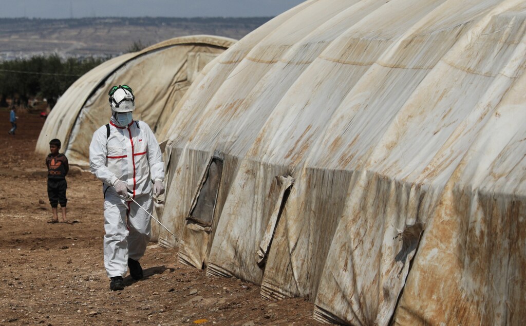 A member of the Syrian Civil defence sanitizes a tent at the Bab Al-Nour internally displaced persons camp, to prevent the spread of coronavirus disease (COVID-19) in Azaz, Syria March 26, 2020. REUTERS/Khalil Ashawi - RC2TRF97H5XC