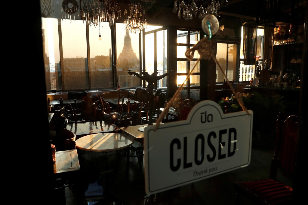 A closed restaurant due to the coronavirus disease (COVID-19) outbreak, is seen next to the Chao Phraya river with a view of Wat Arun temple, one of the city's top tourist spots, in Bangkok, Thailand March 27, 2020. REUTERS/Jorge Silva - RC2FSF9MGL9I