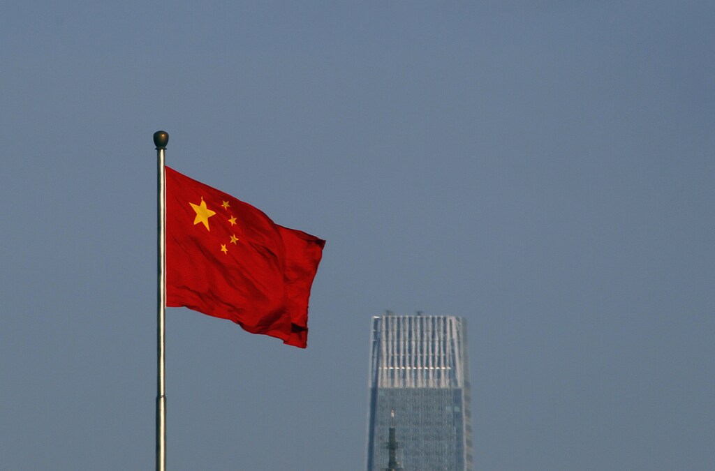 A Chinese national flag flies outside the Xinhua Gate of the Zhongnanhai leadership compound, the residence of China's top leaders, with World Trade Centre Tower III, a 330-meter-tall skyscraper, the tallest in Beijing in the background November 11, 2010. Chinese inflation sped to a 25-month high in October and bank lending blew past expectations, highlighting the challenge faced by Beijing as it battles to keep a lid on price pressures. REUTERS/Petar Kujundzic (CHINA - Tags: POLITICS BUSINESS) - GM1E6BB1EE301