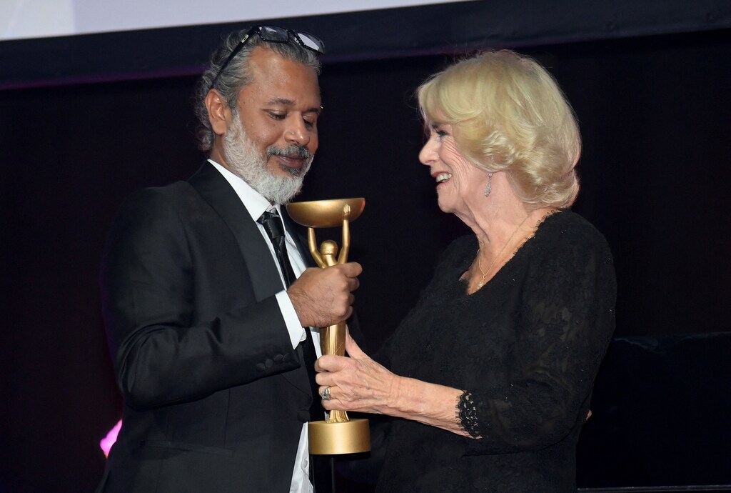 Britain's Queen Camilla presents winner Shehan Karunatilaka with his trophy for 'The Seven Moons of Maali Almeida' at the Booker Prize for Fiction 2022 awards ceremony.
