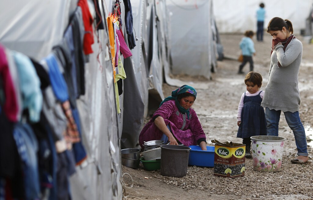 A Kurdish refugee woman from the Syrian town of Kobani washes dishes at a refugee camp in the Turkish border town of Suruc, Sanliurfa province February 2, 2015. The Syrian Kurdish militia that drove Islamic State militants from Kobani with the help of U.S.-led air strikes said on Monday the radical Islamist group may now open new fronts against it in northeastern Syria. Redur Xelil, spokesman for the Kurdish YPG militia, said Islamic State forces were collapsing around Kobani, a town at the border with Turkey that became a focal point for the U.S.-led military campaign against Islamic State in Syria. REUTERS/Umit Bektas (TURKEY - Tags: POLITICS CIVIL UNREST CONFLICT) - RTR4NXW5