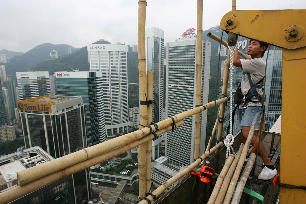 A man works on the bamboo scaffolding on the 50th floor of the Far East Finance Center in Hong Kong September 9, 2006. REUTERS/Paul Yeung (HONG KONG) - GM1DTLVRLGAA