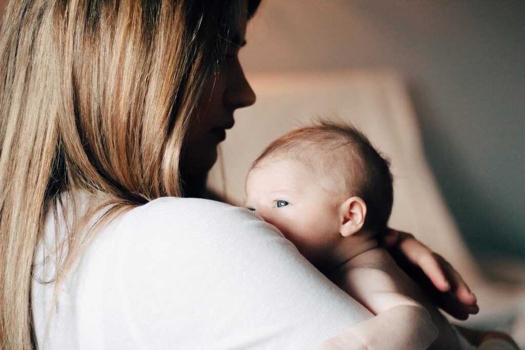 Woman holding newborn child.