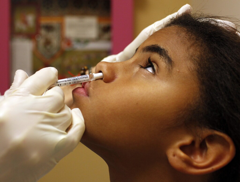 Eleven year-old Kerimal Suriel receives an H1N1 swine flu vaccine at the Children's Hospital Boston primary care clinic in Boston, Massachusetts October 7, 2009. REUTERS/Brian Snyder (UNITED STATES SCI TECH) - GM1E5A80H4C01