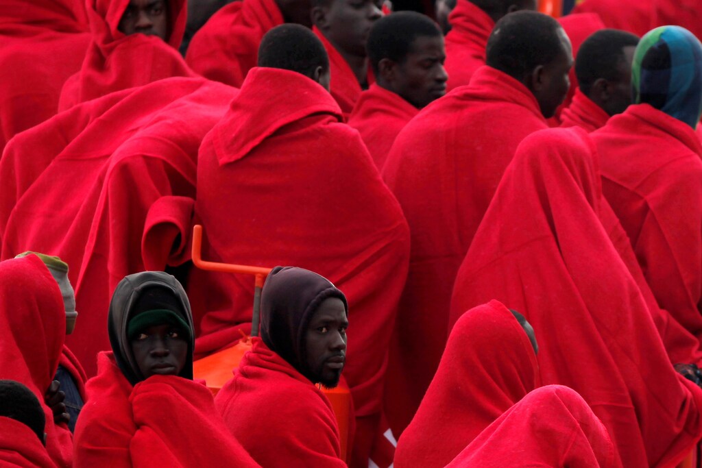 Migrants, who were part of a group intercepted aboard a dinghy off the coast in the Mediterranean sea, wrapped in blankets on a rescue boat upon arriving at a port in Malaga, southern Spain, December 3, 2016. REUTERS/Jon Nazca - RTSUHI6
