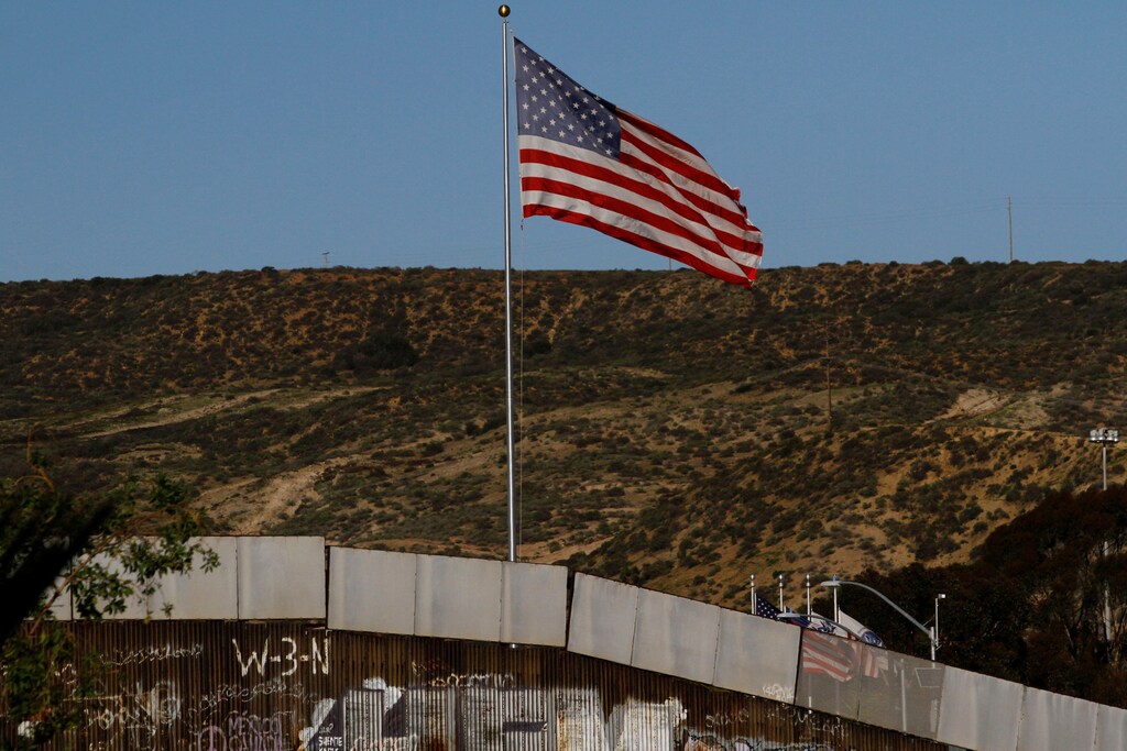A U.S. flag is seen next to a section of the wall separating Mexico and the United States, in Tijuana, Mexico, January 28, 2017. REUTERS/Jorge Duenes - RTSXUGU