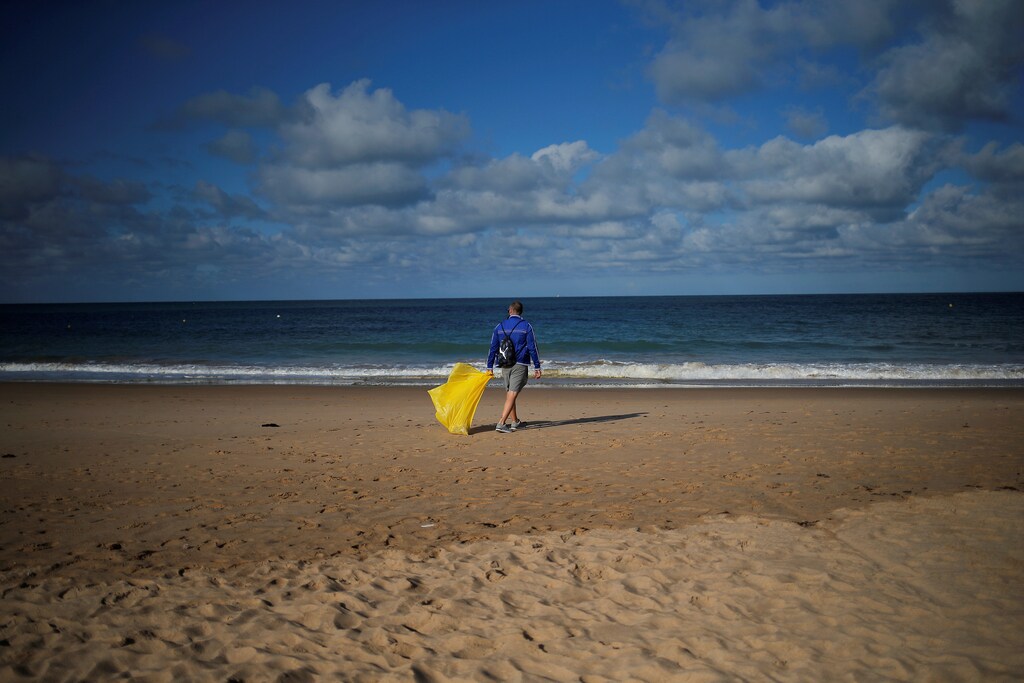 A volunteer walks as he picks up plastics, during a garbage collection, ahead of World Environment Day on La Costilla Beach, on the coast of the Atlantic Ocean in Rota, Spain June 2, 2018. REUTERS/Jon Nazca TPX IMAGES OF THE DAY - RC1E38679580