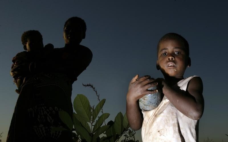 A young girl carries a pumpkin at a maize field in Masongo village outside Lilongwe, Malawi May 13,2008.