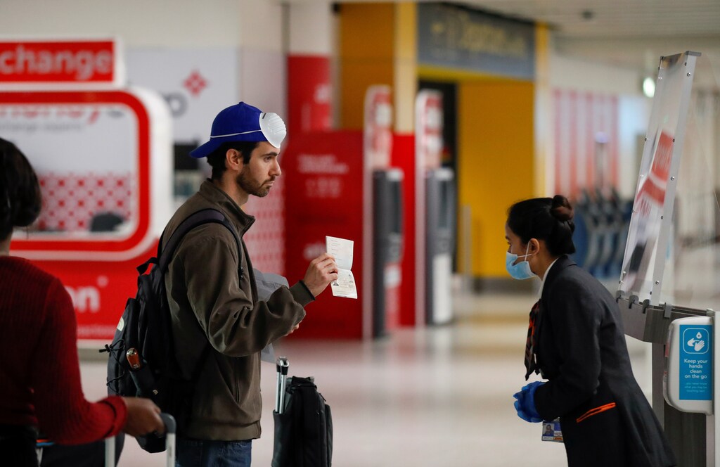 A passenger shows his passport to a staff member at Gatwick Airport, amid the coronavirus disease (COVID-19) outbreak, in Gatwick, Britain June 15, 2020.