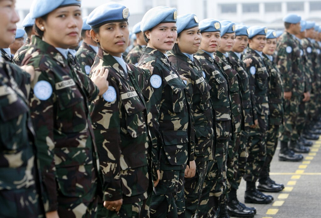 Female members of a Philippine peacekeeping force bound for Liberia stand at attention during a send-off ceremony at the military headquarters in Manila January 28, 2009. A battalion of Filipino soldiers will take part in United Nations peacekeeping missions in Haiti and Liberia. REUTERS/Romeo Ranoco (PHILIPPINES) - GM1E51S17C201