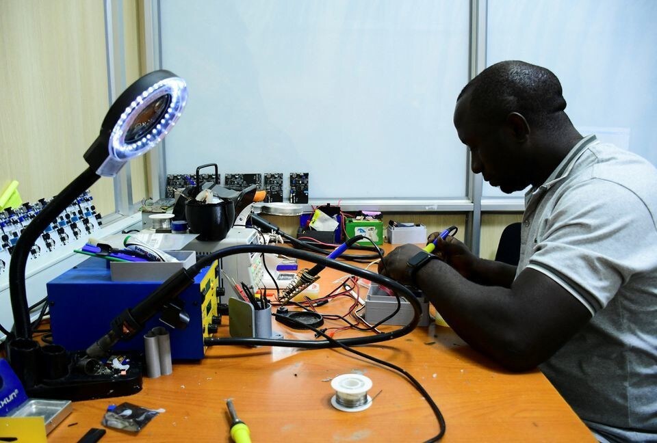 Joel Ssematimba works on air quality monitoring devices inside a workshop at the Makerere University in Kampala, Uganda.
