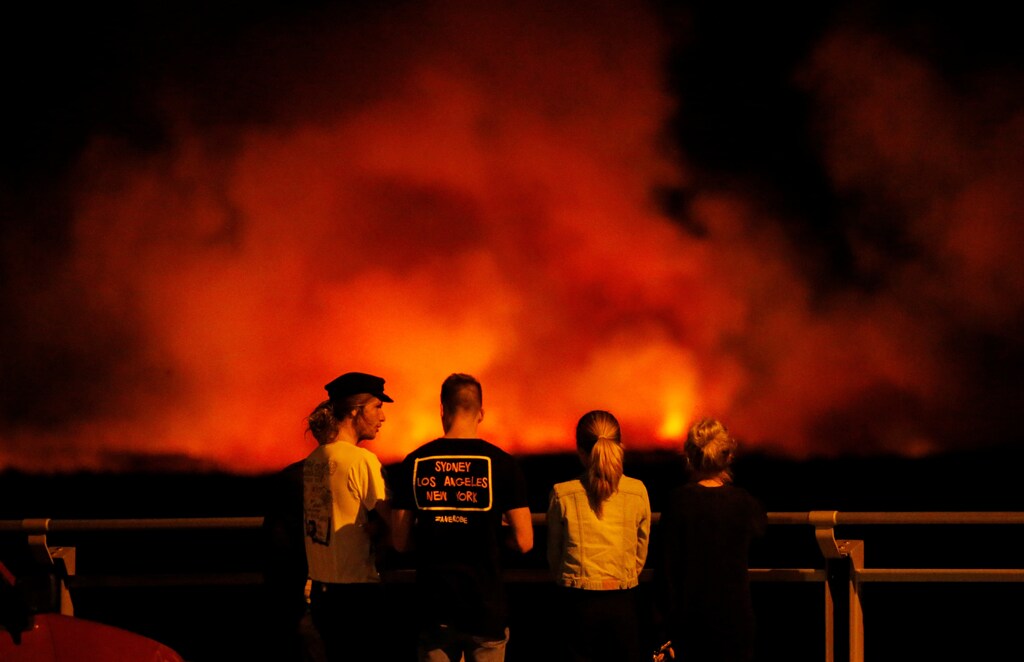 People watch a bushfire burning on the Kurnell Peninsula, during an unseasonably warm start to Spring, on Sydney's southern coast, Australia September 3, 2017. REUTERS/Jason Reed - RC157C5CAF00