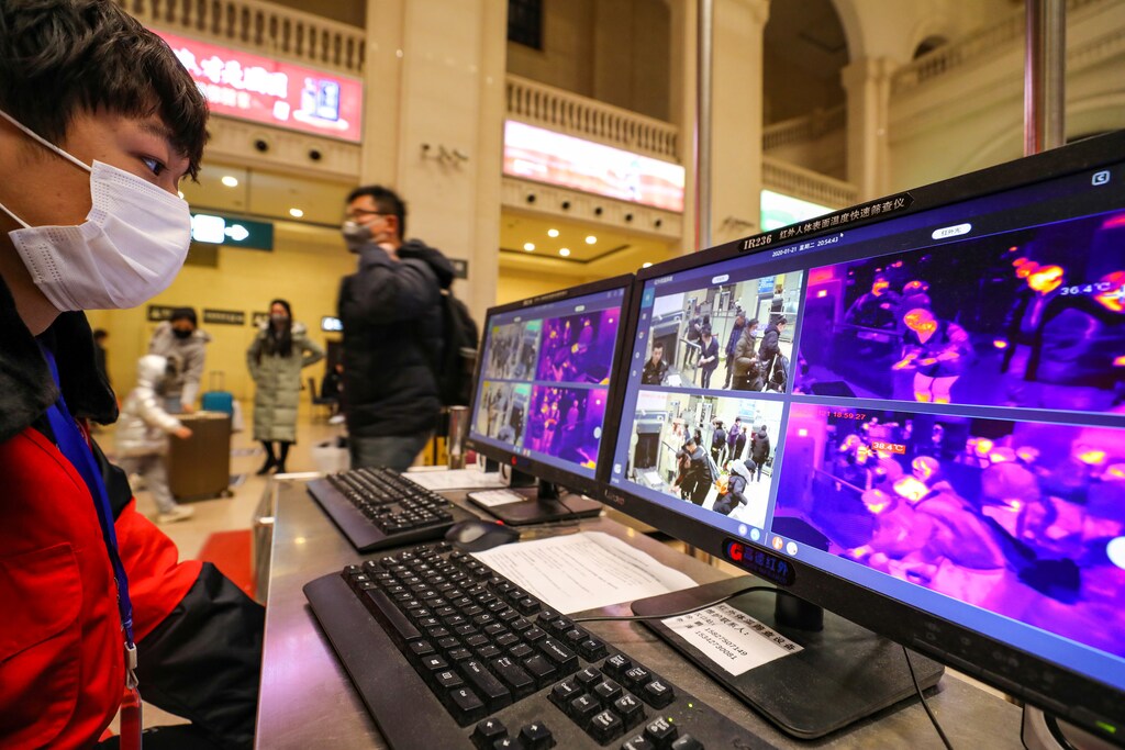 A staff member wearing a mask monitors thermal scanners that detect temperatures of passengers at the security check inside the Hankou Railway Station in Wuhan, Hubei province, China January 21, 2020. Picture taken January 21, 2020. China Daily via REUTERS ATTENTION EDITORS - THIS IMAGE WAS PROVIDED BY A THIRD PARTY. CHINA OUT. - RC2VKE9Z9HTK
