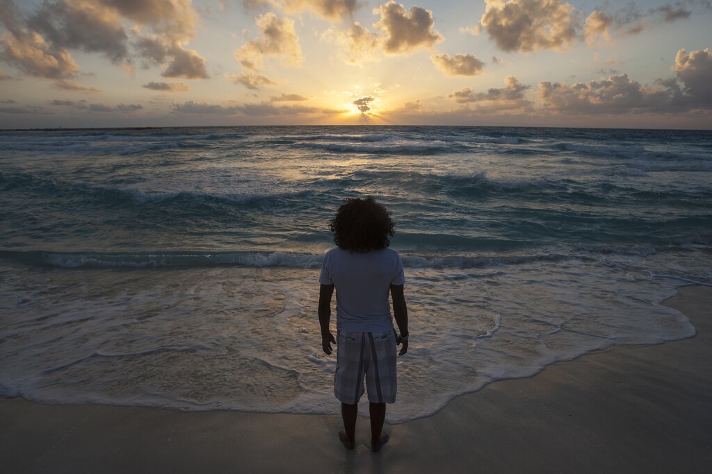 A man watches the sunrise on New Year's Day at Gaviota Azul beach in Cancun January 1, 2014.