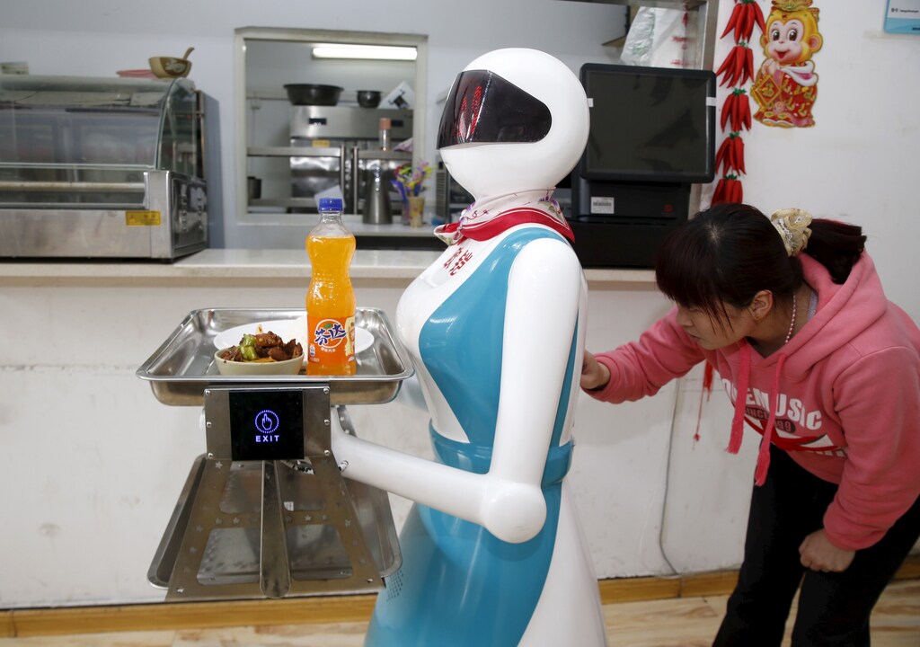 A woman input orders for a waitress robot in a restaurant in Xi'an, China