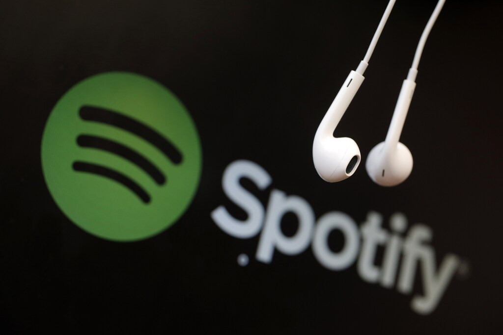 Headphones are seen in front of a logo of online music streaming service Spotify in this illustration picture taken in Strasbourg, February 18, 2014. Spotify is recruiting a U.S. financial reporting specialist, adding to speculation that the Swedish start-up is preparing for a share listing, which one banker said could value the firm at as much as $8 billion. REUTERS/Christian Hartmann (FRANCE - Tags: BUSINESS ENTERTAINMENT LOGO) - GM1EA2I1FYB01