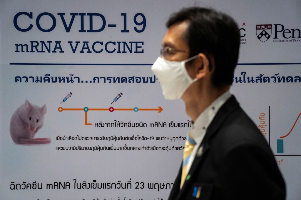 A man wearing a face mask stands next to a board showing the progress of developing an mRNA type vaccine candidate for the coronavirus disease (COVID-19) during a news conference at the National Primate Research Center of Chulalongkorn University in Saraburi province, Thailand, June 22, 2020. REUTERS/Athit Perawongmetha - RC29EH91GIEK