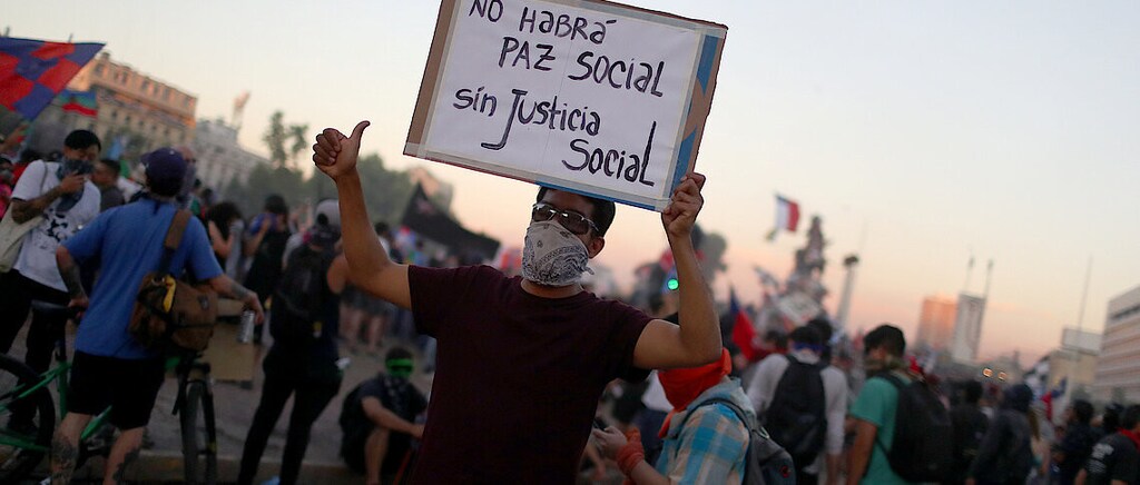 Boards and the businesses they oversee have an increasingly important role in ensuring human rights are upheld. Pictures here is a man holding up a placard during a street protest.