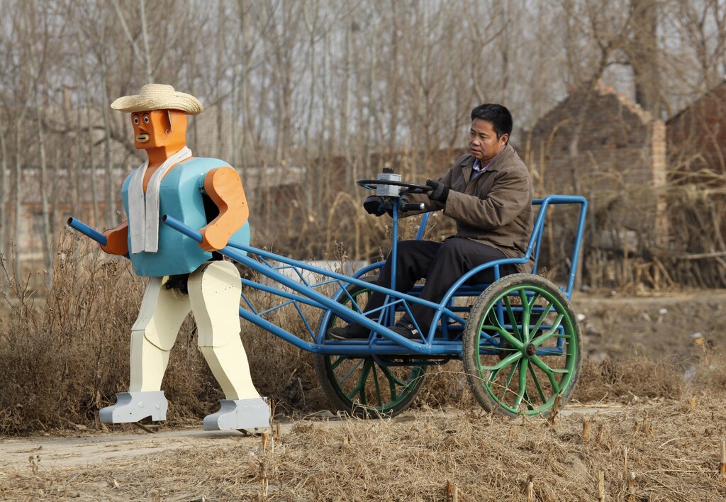Farmer Wu Yulu drives his rickshaw pulled by a his home-made walking robot near his home in a village at the outskirts of Beijing January 8, 2009. This robot is the latest and largest development of hobby inventor Wu, who started to build robots in 1986, made of wire, metal, screws and nails found in rubbish sites