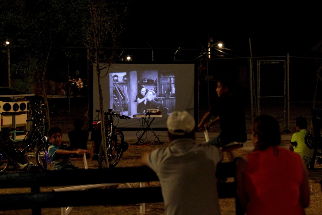 Residents watch a film projected by the Cinecleta, Moviebike, at a park in Saltillo, Mexico, September 6, 2015. Reginaldo Chapa modified a cargo bike to create the Cinecleta, a pedal-driven vehicle that carries a solar powered battery, a projector and sound equipment which it's aimed to promote clean energy and to take films and music to rough neighbourhoods in this industrial city, local media reported. Picture taken September 6, 2015. REUTERS/Daniel Becerril - GF10000199178