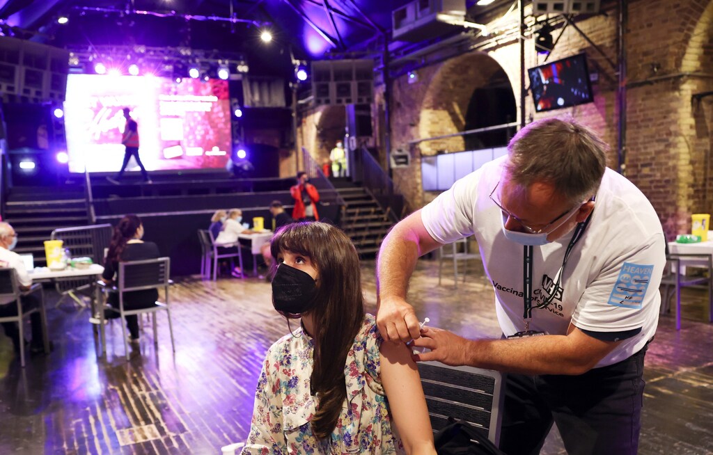A person receives a dose of the Pfizer BioNTech vaccine at an NHS vaccination centre hosted at the Heaven nightclub, amid the coronavirus disease (COVID-19) pandemic, in London, Britain, August 8, 2021. REUTERS/Henry Nicholls - RC211P9TJS8P