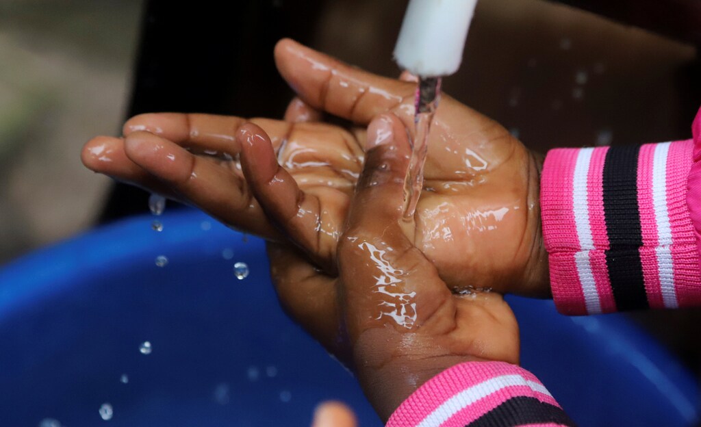 A Congolese child washes her hands as a preventive measure against Ebola at the Church of Christ in Mbandaka, Democratic Republic of Congo May 20, 2018. REUTERS/Kenny Katombe - RC1764777230