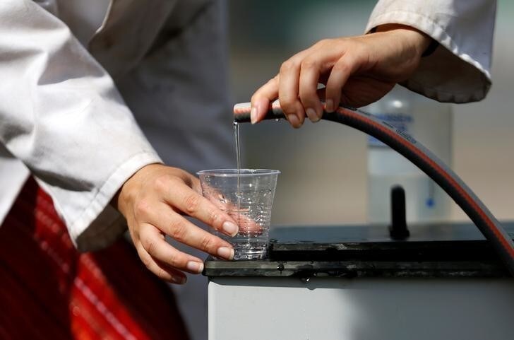 Belgian scientist Marjolein Vanoppen pours water from a machine that turns urine into drinkable water and fertilizer using solar energy, at the University of Ghent, Belgium, July 26, 2016. REUTERS/Francois Lenoir