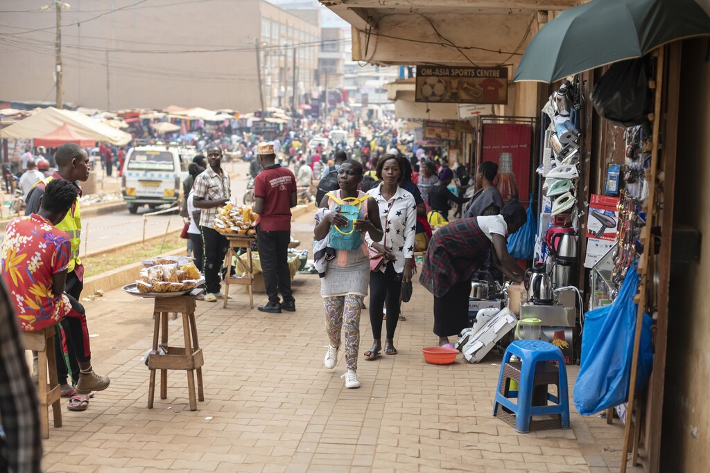 Kampala, Uganda - January 12th, 2020: Unidentified woman carries her backpack on a chest along a street of Kampala, Uganda. Carrying backpacks in front is common practice to prevent pickpocketing.