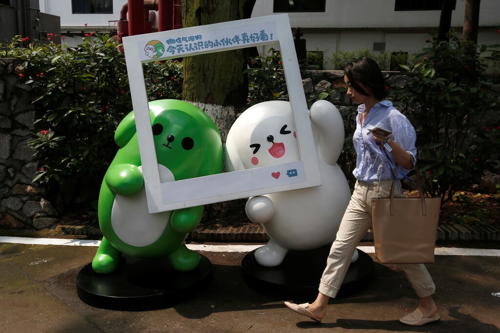 A girl walks past WeChat mascots inside TIT Creativity Industry Zone where Tencent office is located in Guangzhou, China May 9, 2017. Picture taken May 9, 2017. REUTERS/Bobby Yip - RC12AA19C0C0