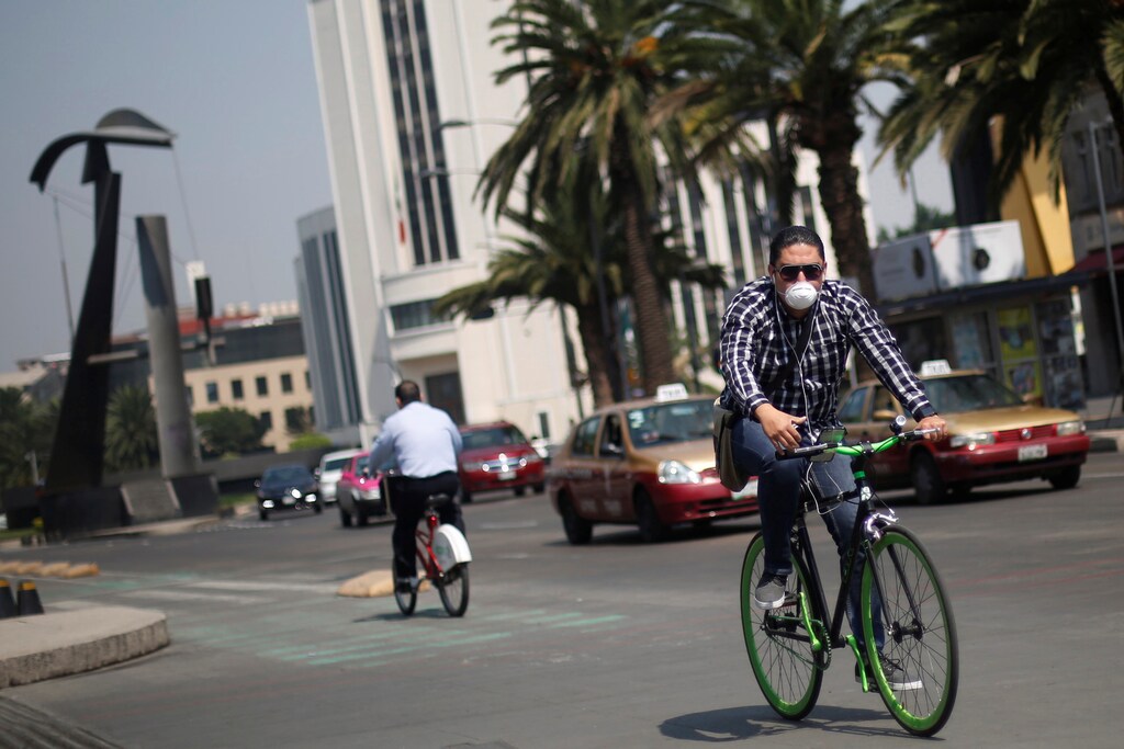 A cyclist wearing a mask is seen on a day of traffic restrictions from the Mexico City's government campaign to support anti-pollution measures in Mexico City, Mexico, May 5, 2016. REUTERS/Edgard Garrido - RTX2D18B