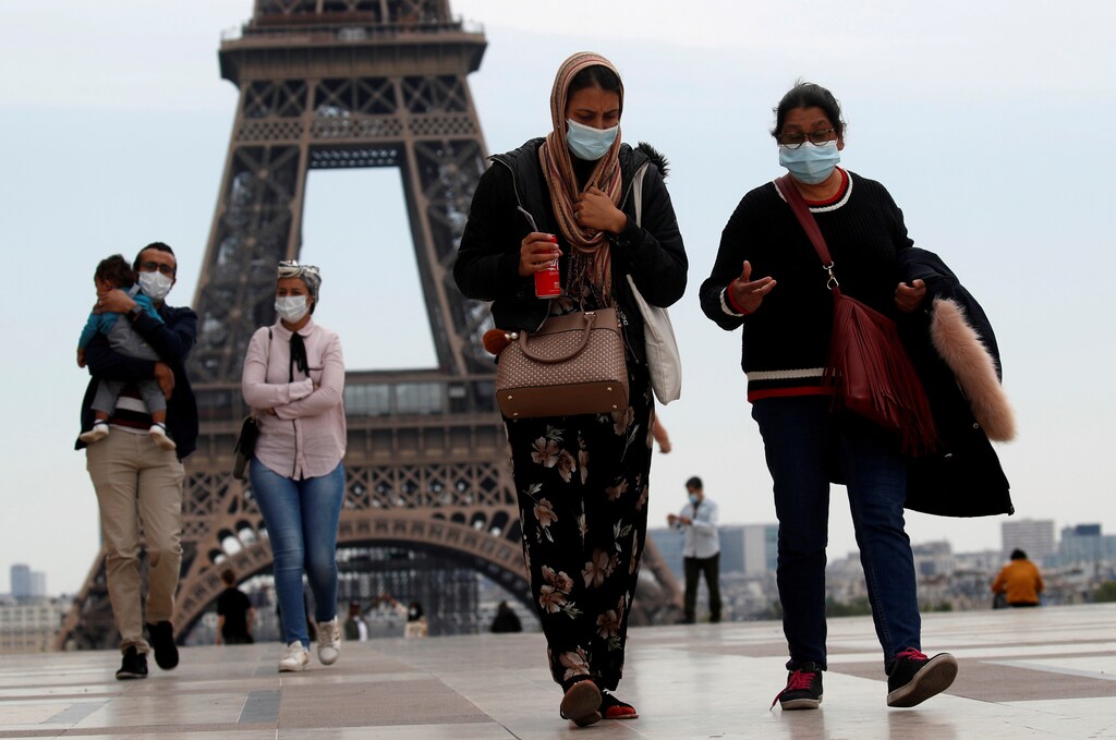 People wearing face masks walk at Trocadero square near the Eiffel Tower, as France began a gradual end to a nationwide lockdown due to the coronavirus disease (COVID-19) in Paris, France, May 16, 2020. REUTERS/Gonzalo Fuentes TPX IMAGES OF THE DAY - RC2OPG9EW4WV