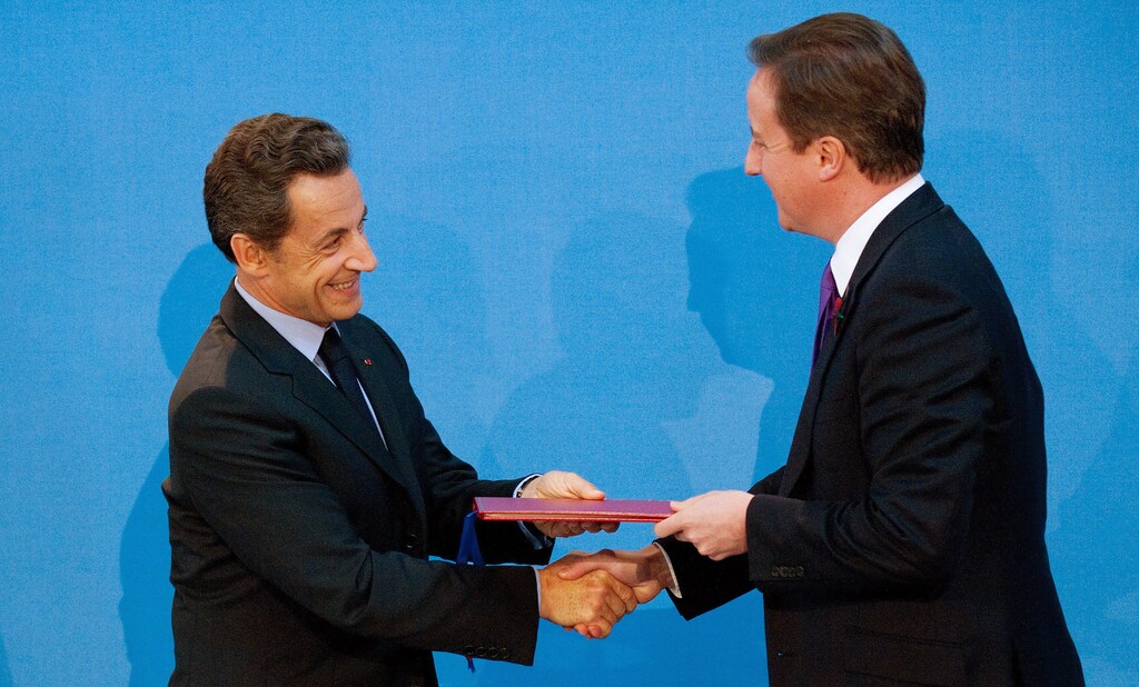 Britain's Prime Minister David Cameron (R) and France's President Nicholas Sarkozy shake hands after signing a treaty during an Anglo-French summit at Lancaster House in London November 2, 2010. Britain and France agreed on Tuesday to set up a joint military force and share equipment and nuclear missile research centres in what Prime Minister David Cameron hailed as a new chapter in their relations. REUTERS/Leon Neal/POOL (BRITAIN - Tags: POLITICS MILITARY) - LM1E6B214OZ01
