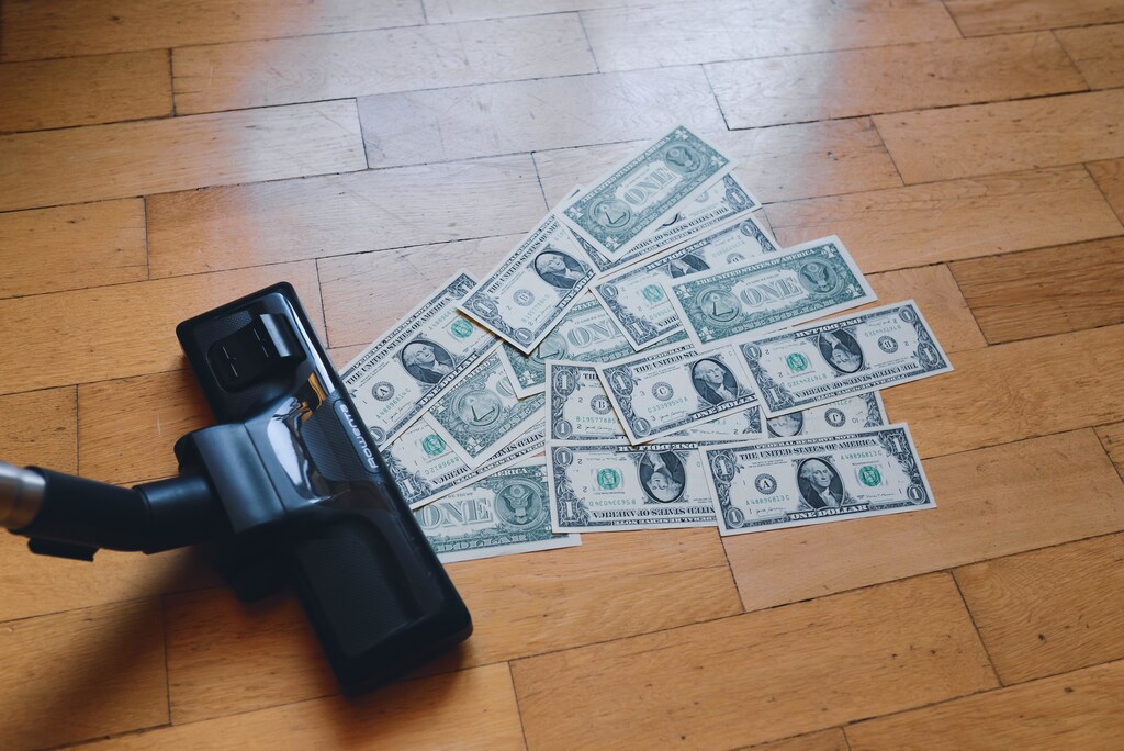 A vacuum cleaner hoovering up one-dollar notes.