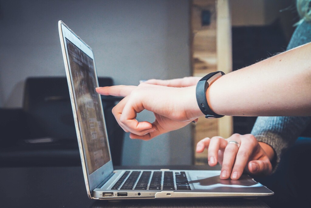 Two people working at a laptop.