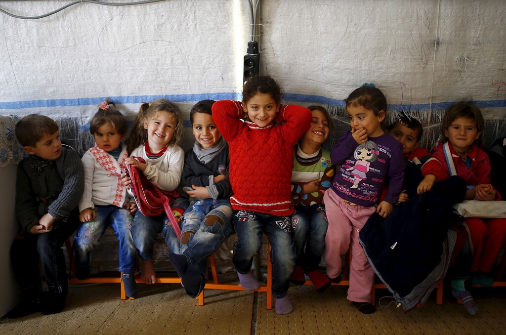 Syrian refugee girl Ele Cundi, 5, poses as she sits with her friends in a kindergarten at Midyat refugee camp in Mardin province, Turkey, December 14, 2015.