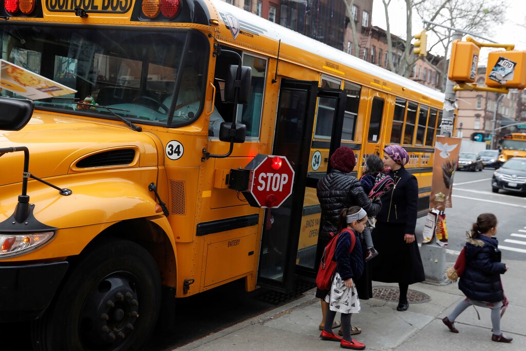 Orthodox Jewish children get off a Yeshiva school bus, as New York City Mayor Bill de Blasio declared a public health emergency in parts of Brooklyn in response to a measles outbreak, in the Williamsburg neighborhood of Brooklyn in New York City, U.S., April 9, 2019. REUTERS/Shannon Stapleton - RC188F6815D0