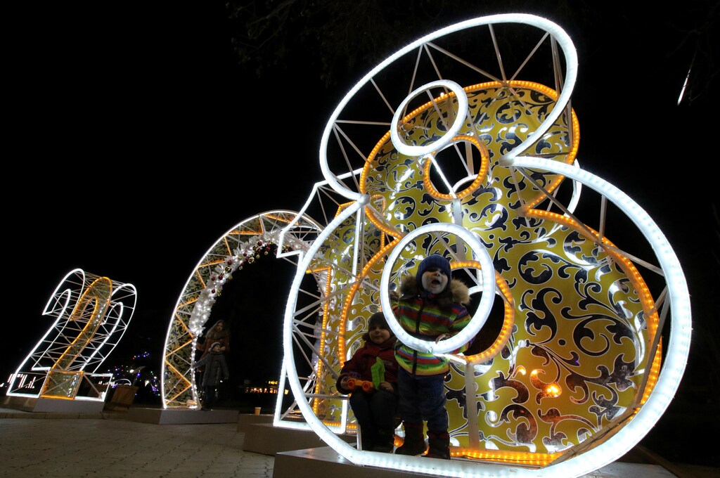Children play on festive decorations for the New Year and Christmas season in the resort city of Yevpatoriya, Crimea December 28, 2017. REUTERS/Pavel Rebrov - RC1CDB735610