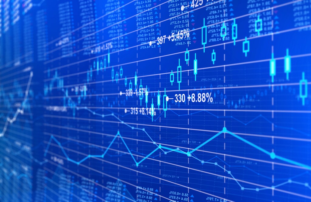 Financial stock market background on a blue digital display. FMI, charts, diagrams and grids with numbers, tickers, line and bars related to stock exchange rates, financial figures, trading data and market trends. Focus on a candlestick chart. Perspective effect with selective focus. Blue background.