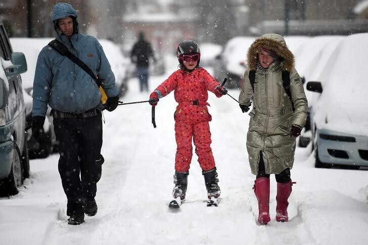 Parents use a ski to go for a walk with their child after schools closed due to adverse weather conditions in Dublin, Ireland, March 2, 2018. REUTERS/Clodagh Kilcoyne