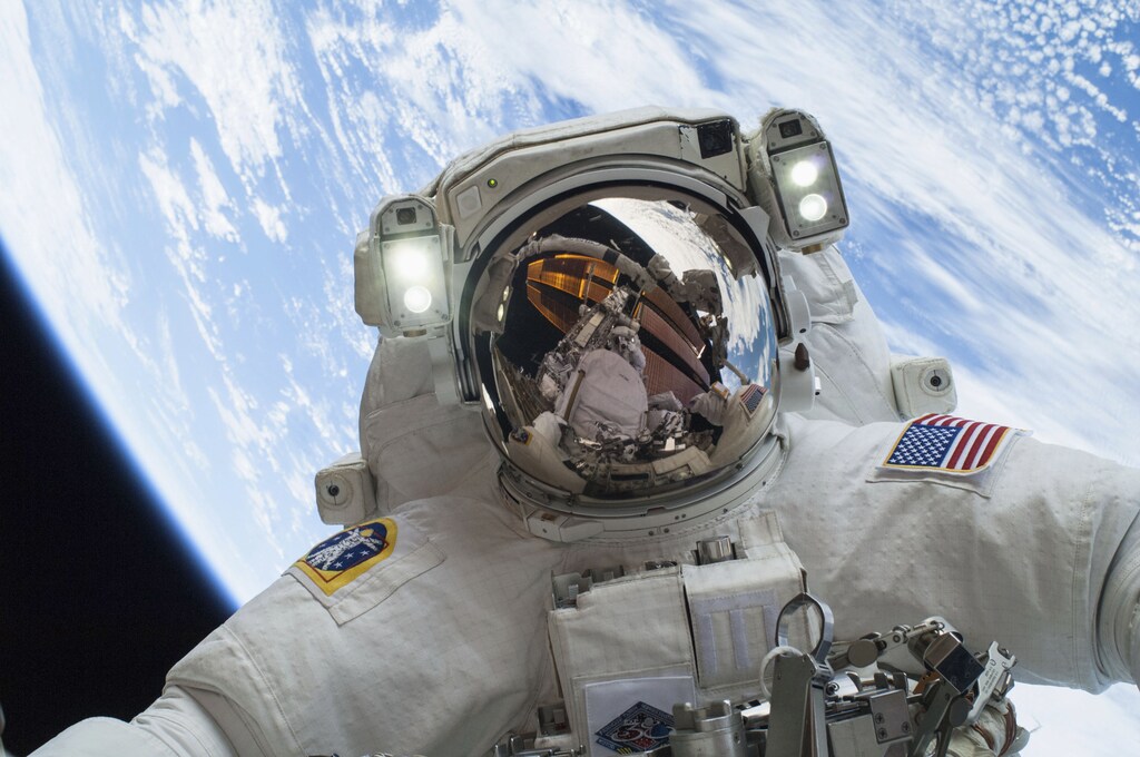Astronaut Mike Hopkins, Expedition 38 Flight Engineer, is shown in this handout photo provided by NASA as he participates in the second of two spacewalks which took place on December 24, 2013, released on December 27, 2013. The scheduled spacewalks were designed to allow the crew to change out a faulty water pump on the exterior of the Earth-orbiting International Space Station. He was joined on both spacewalks by NASA astronaut Rick Mastracchio, whose image shows up in Hopkins' helmet visor. REUTERS/NASA/Handout via Reuters space travel space aerospace nasa astronaut science the moon artemis apollo mission international space station iss astronaut science physics solar system sun travel endeavor