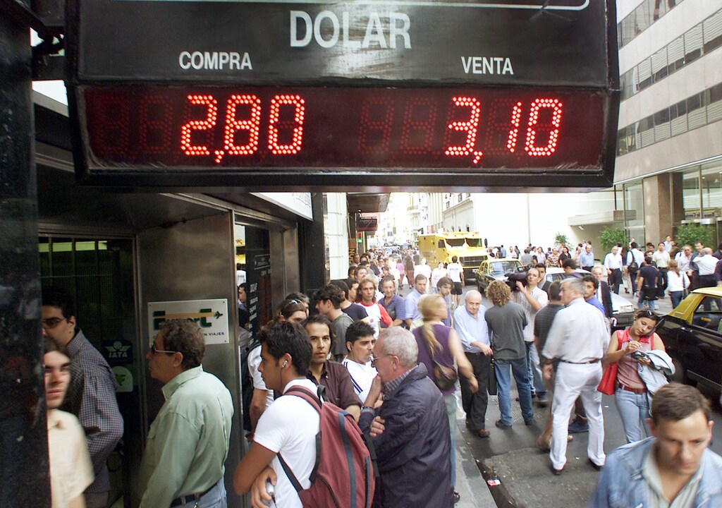 Hundreds of Argentines line up outside exchange houses in Buenos Aires'financial district to buy dollars as the peso dropped to record lows,March 22, 2002. Argentina's peso plummeted to record lows despite efforts by the Central Bank to prop up the local currency.REUTERS/Enrique MarcarianRR/SV - RP3DRHZFINAA
