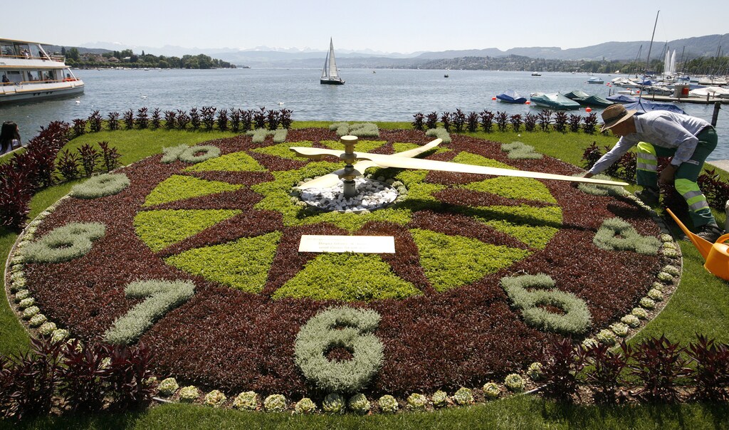 A gardener prepares the dial made of plants, of a giant clock during sunny summer weather at the borders of Lake Zurich in Zurich July 27, 2009. REUTERS/Arnd Wiegmann (SWITZERLAND ENVIRONMENT) - BM2E57R15S901