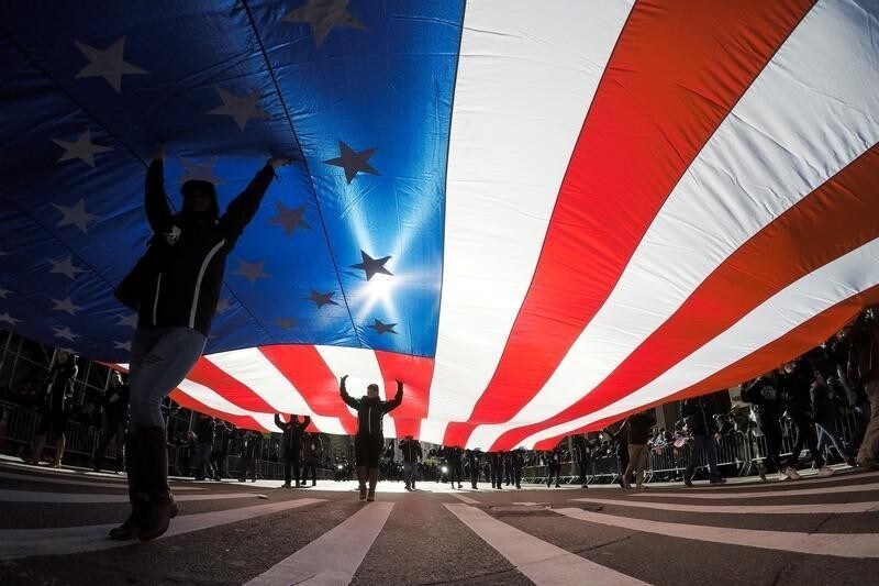 People carry the U.S. flag during the Veteran's Day parade in New York, U.S., November 11, 2017. REUTERS/Eduardo Munoz - RC156DECB7B0