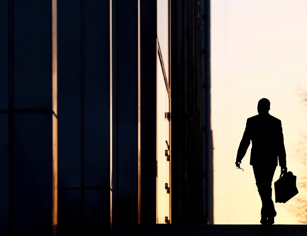 A worker arrives at his office in the Canary Wharf business district in London, Britain, February 26, 2014. REUTERS/Eddie Keogh/File Photo - D1BEUDWWFEAA